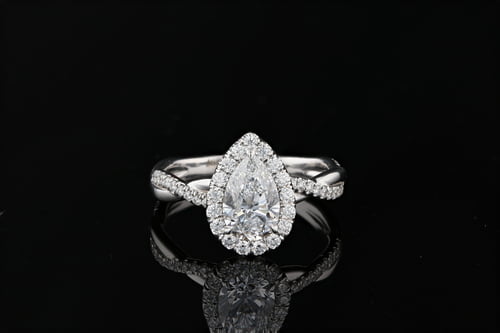 Pear shaped diamond, halo engagement ring with a braided pave set diamond band
