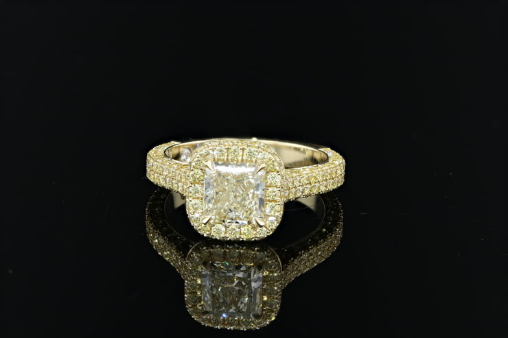 Three sided pave radiant cut yellow diamond halo ring with pave set round brilliant cut yellow diamonds